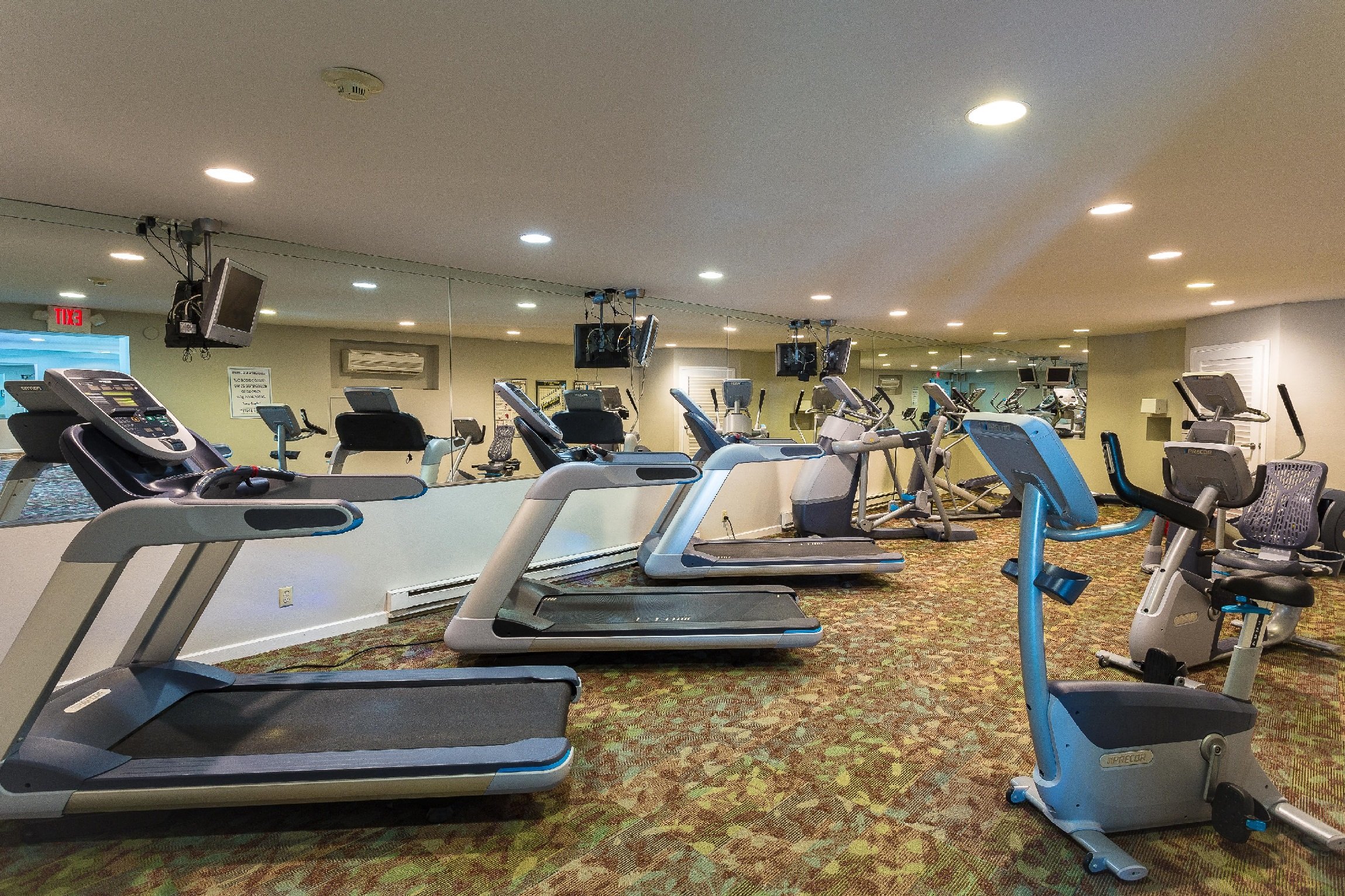 Fitness center with televisions, treadmills, and indoor bicycles